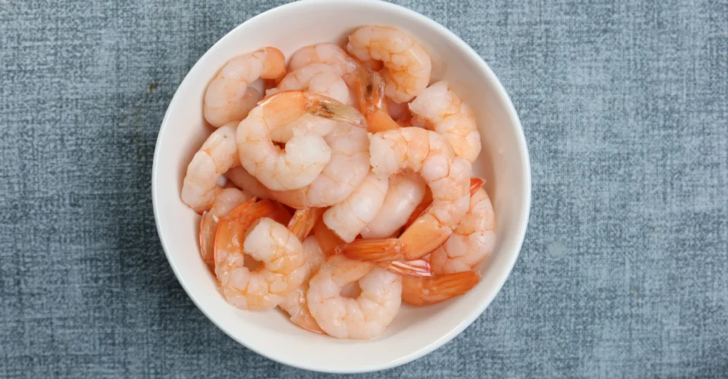 Bowl of plain cooked and peeled shrimp, safe to serve to dogs in small portions