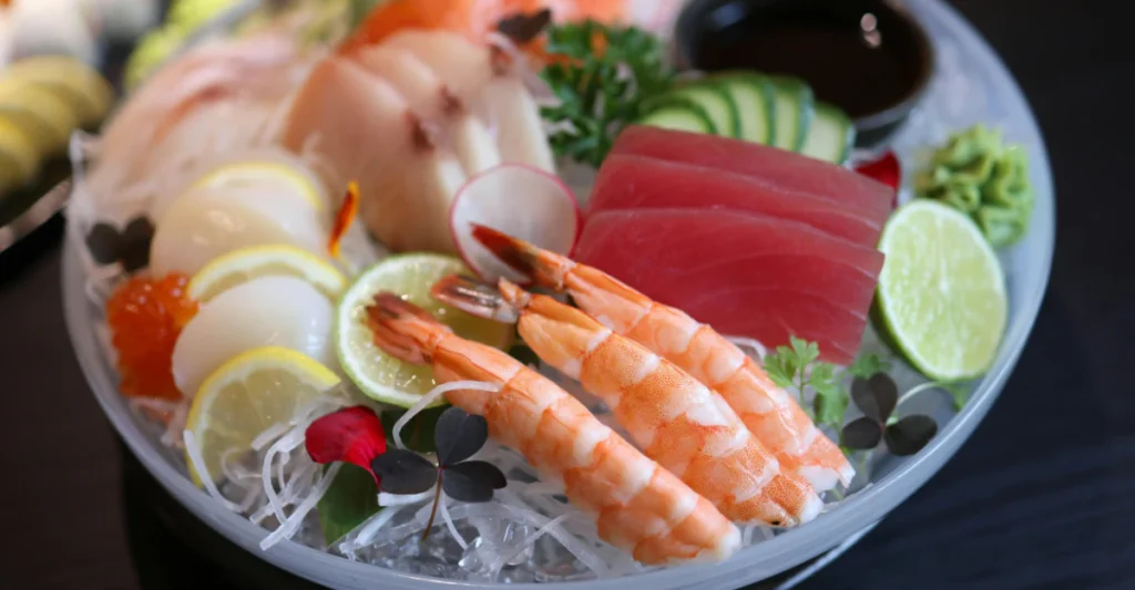 Seafood platter with shrimp, sashimi, and lemon slices, compared to shrimp for dogs