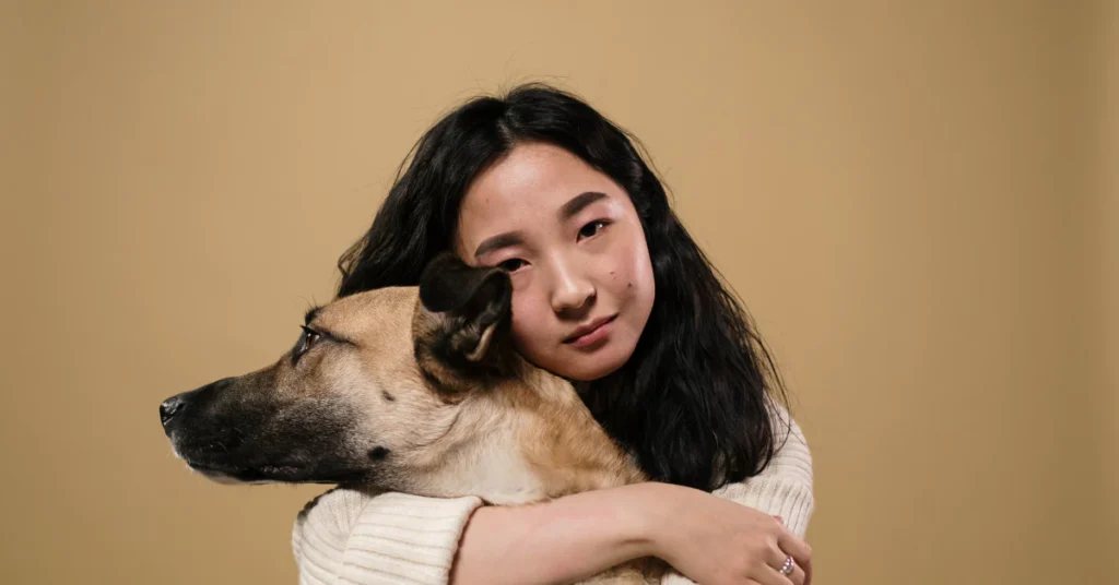 Woman hugging her dog close, looking concerned
