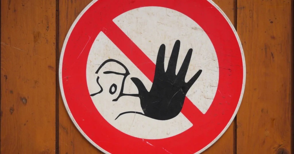 Red prohibition sign with a hand symbol warning not to do something